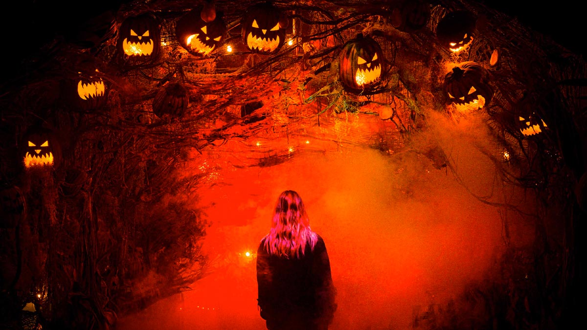 woman under arch with jack o lanterns at Los Angeles Haunted Hayride at Griffith Park in Los Angeles, California, USA